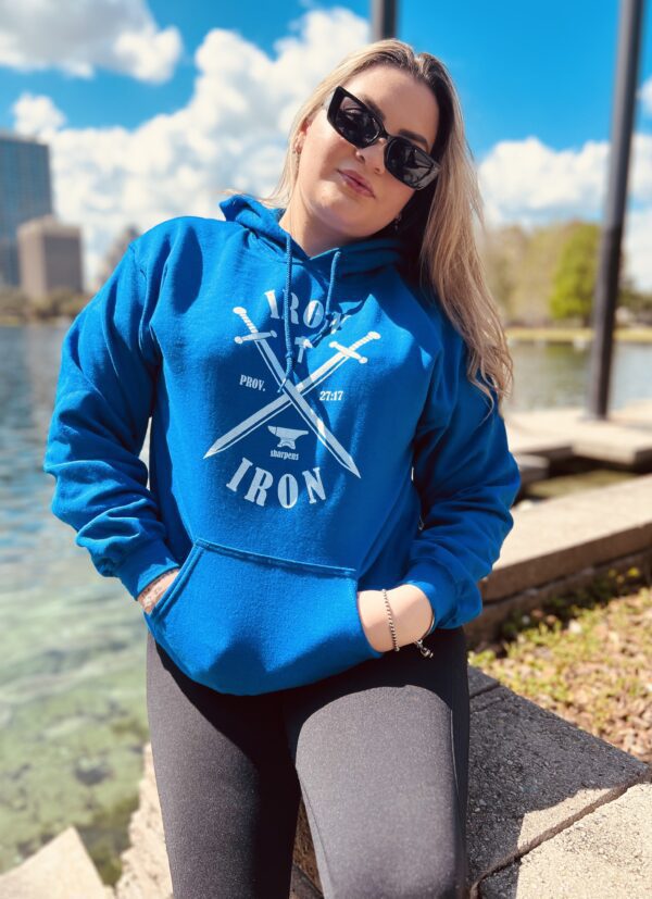 A girl wearing a blue sweat shirt near a lake