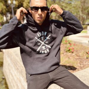 A boy wearing a black sweatshirt near a wall